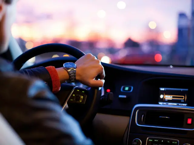 Hände am Lenkrad eines Fahrzeugs bei Abendlicht